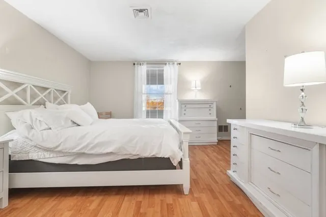 a spacious bedroom with a bed and a dresser