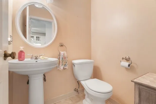 a bathroom with a toilet sink and mirror