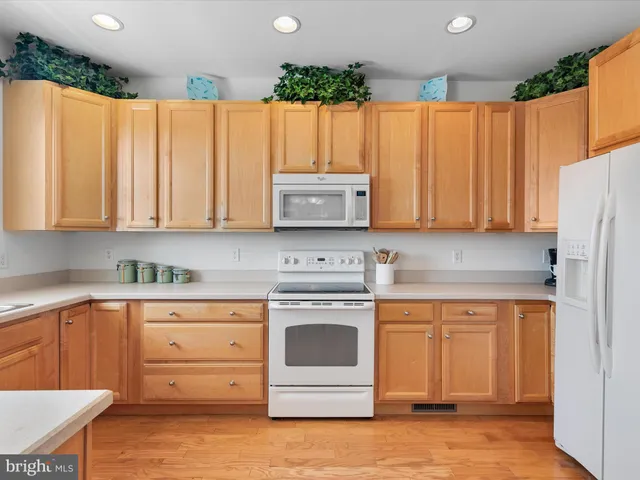 a kitchen with a refrigerator a stove a microwave and cabinets