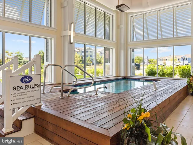a view of swimming pool with lawn chairs under an umbrella