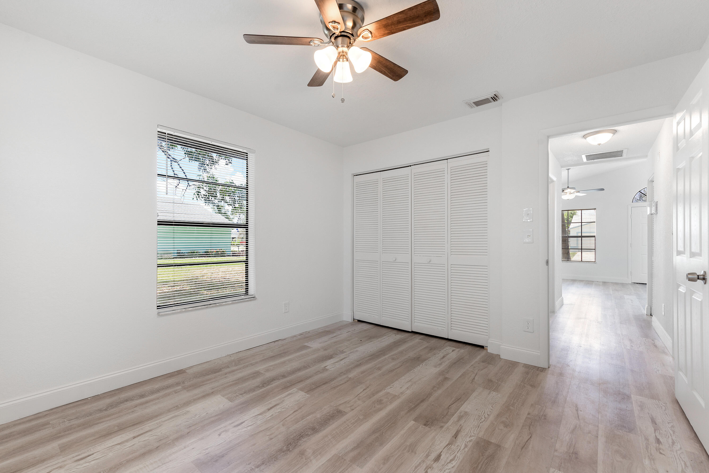 5629 Southeast Collins Avenue Stuart, FL 34997 - Photo 14 of 39 a view of an empty room with wooden floor and a window