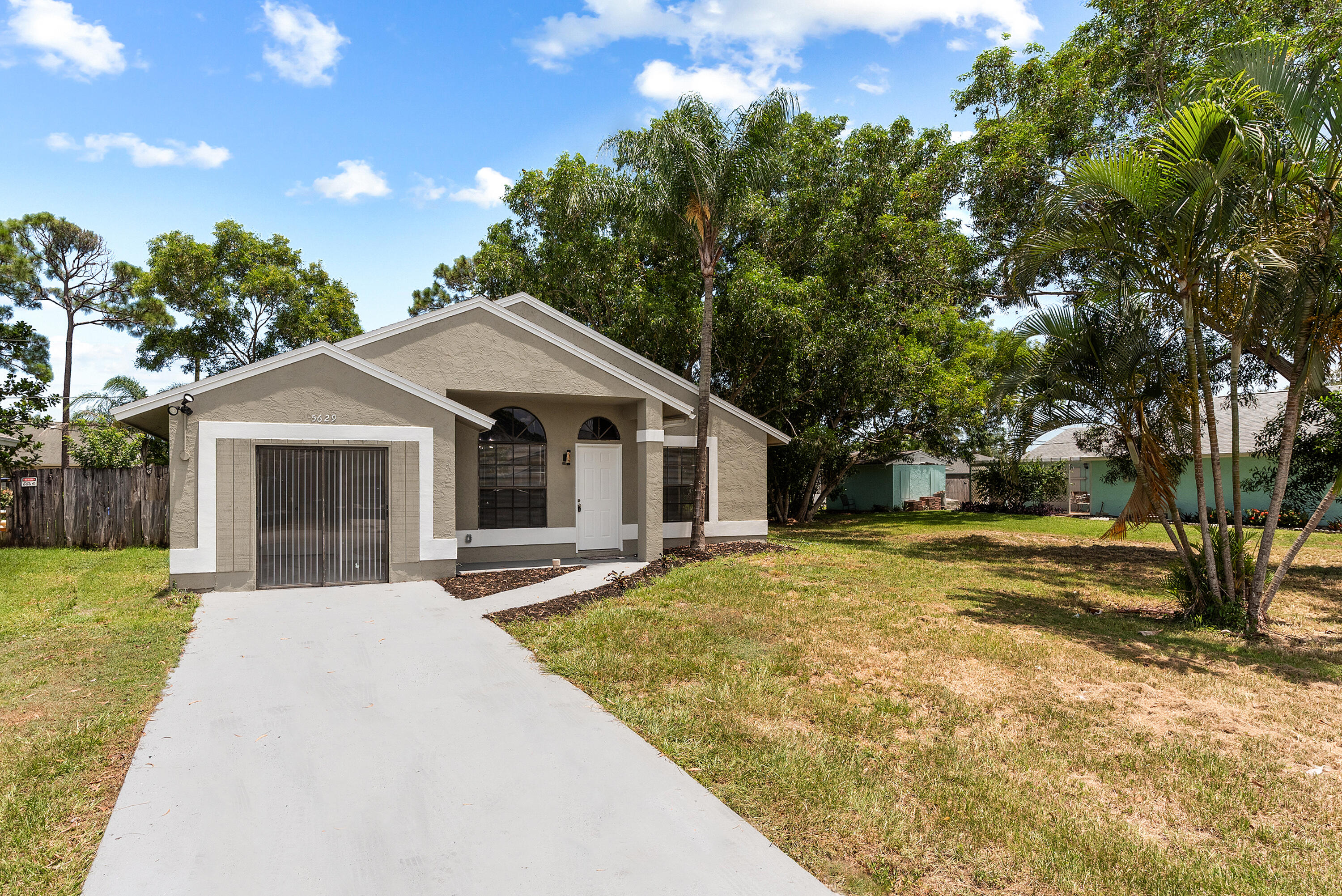 5629 Southeast Collins Avenue Stuart, FL 34997 - Photo 2 of 39 a front view of a house with a yard and trees