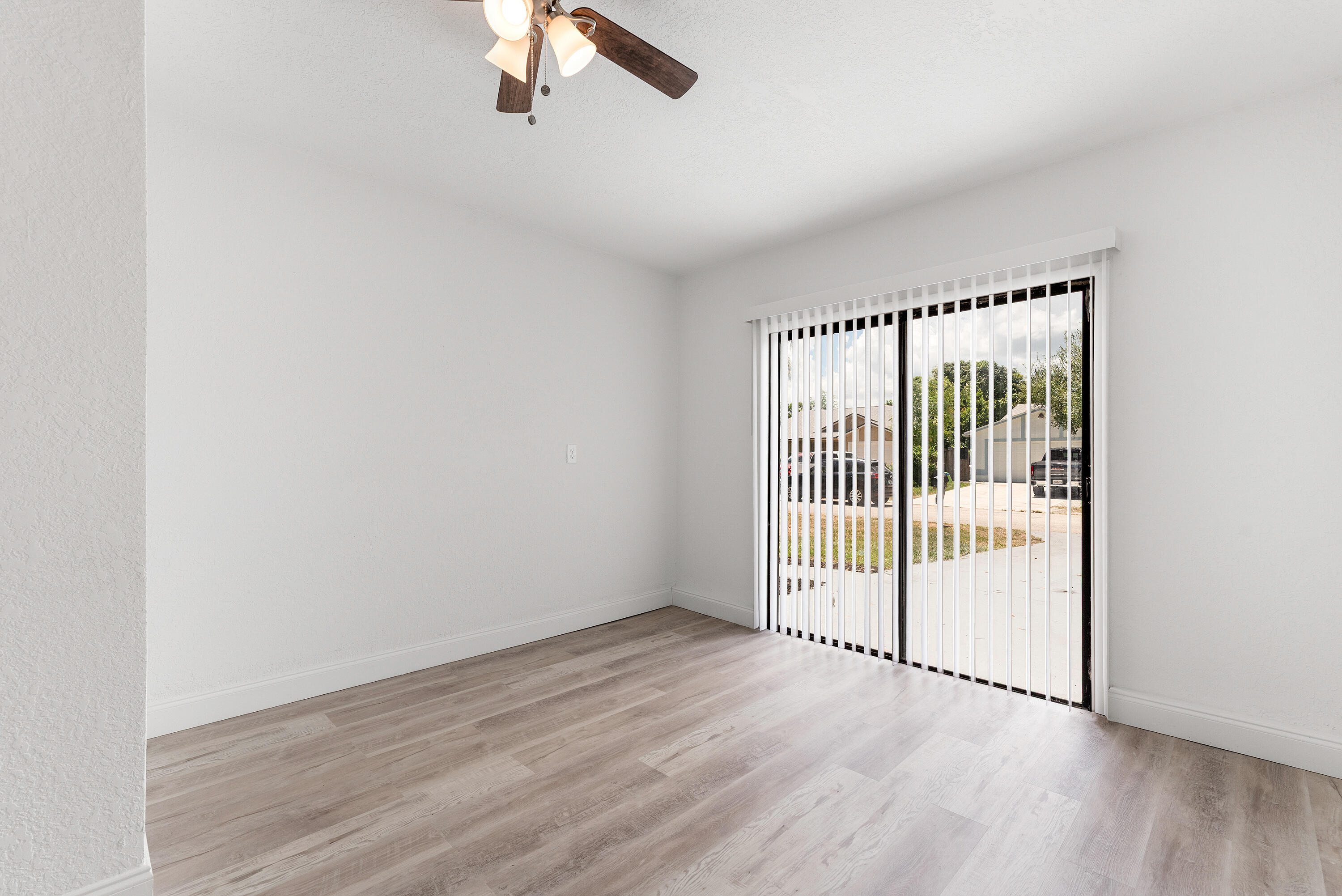 5629 Southeast Collins Avenue Stuart, FL 34997 - Photo 30 of 39 an empty room with wooden floor and windows