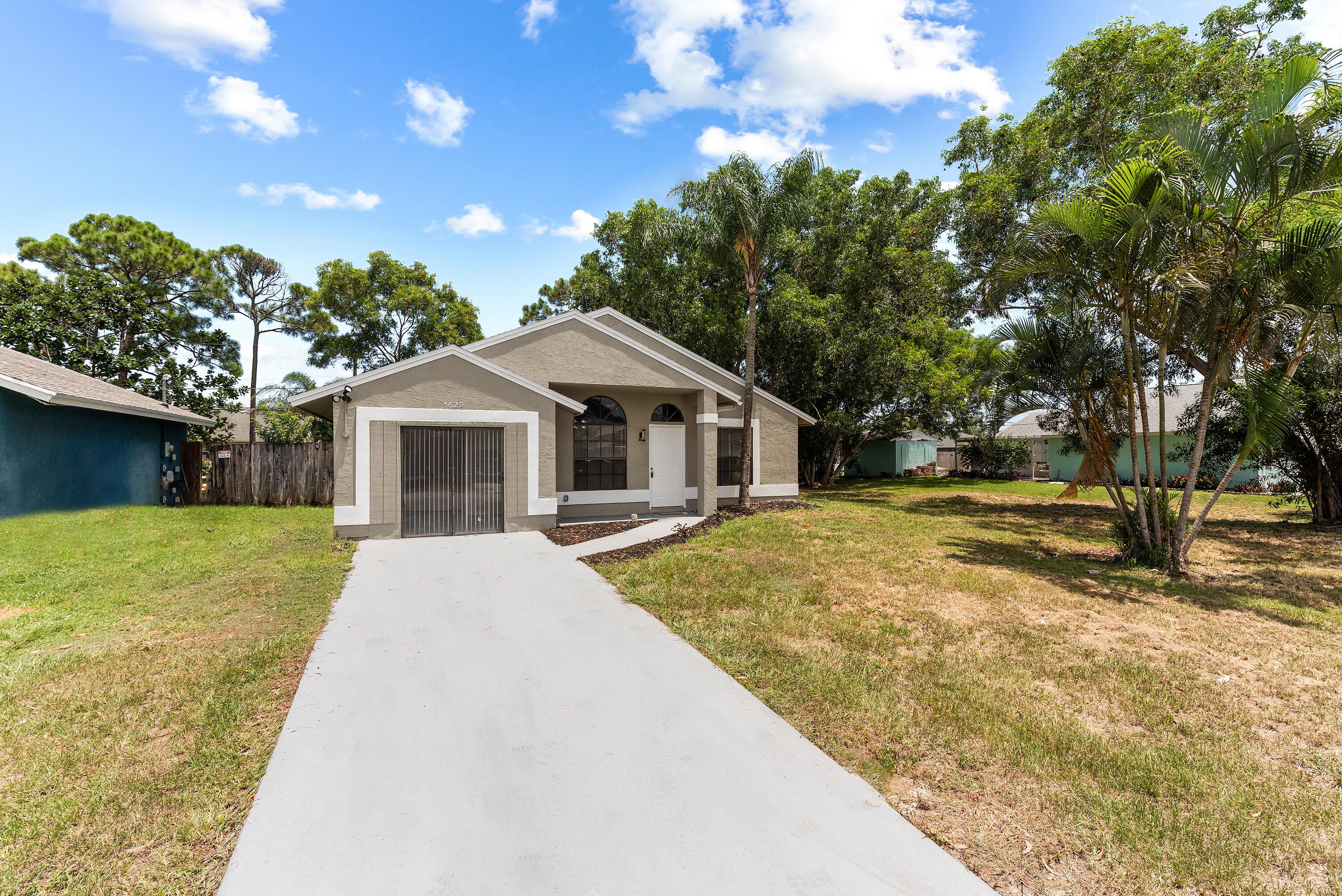 5629 Southeast Collins Avenue Stuart, FL 34997 - Photo 33 of 39 a yellow house with trees in front of it