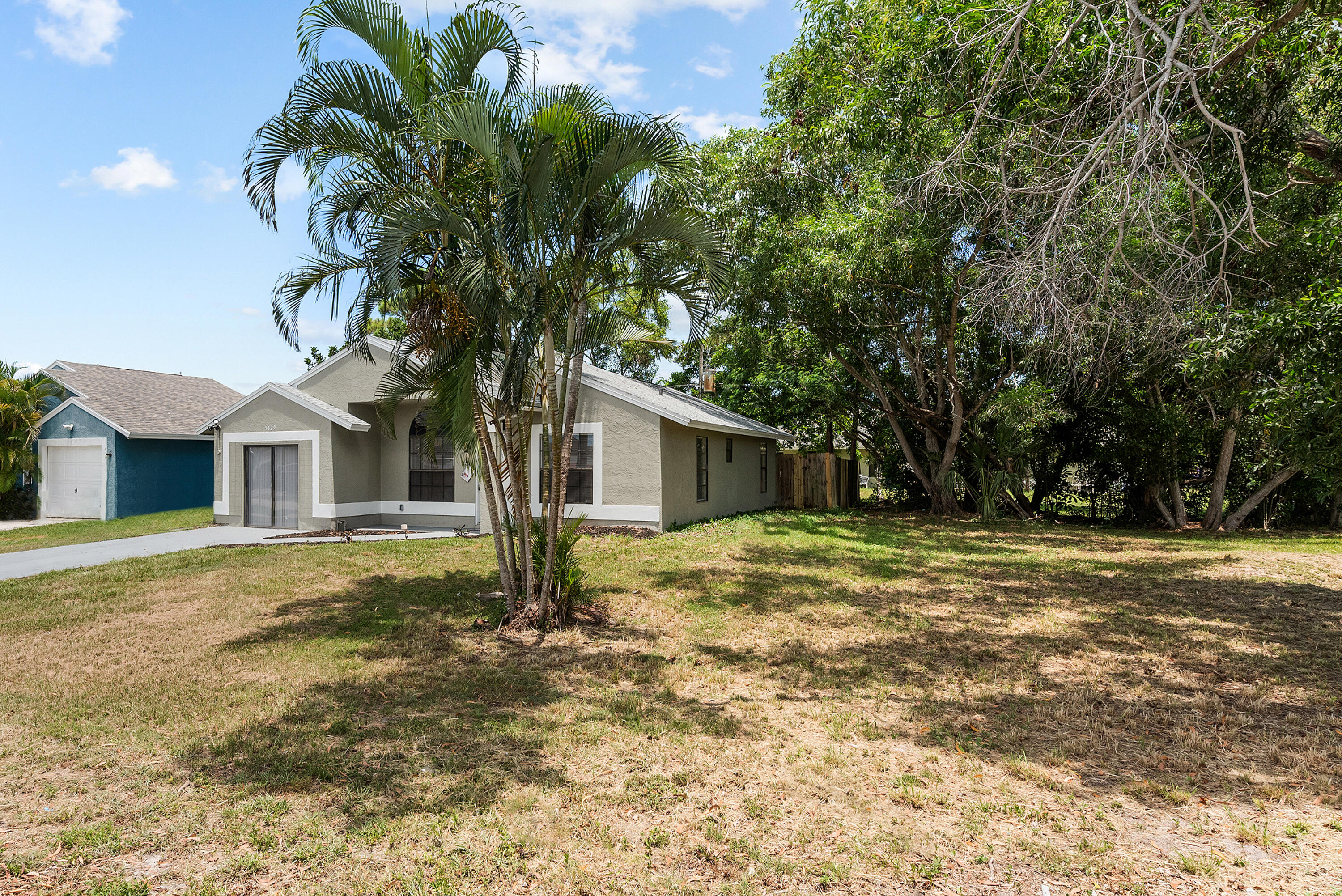5629 Southeast Collins Avenue Stuart, FL 34997 - Photo 36 of 39 a tree in front of a white house