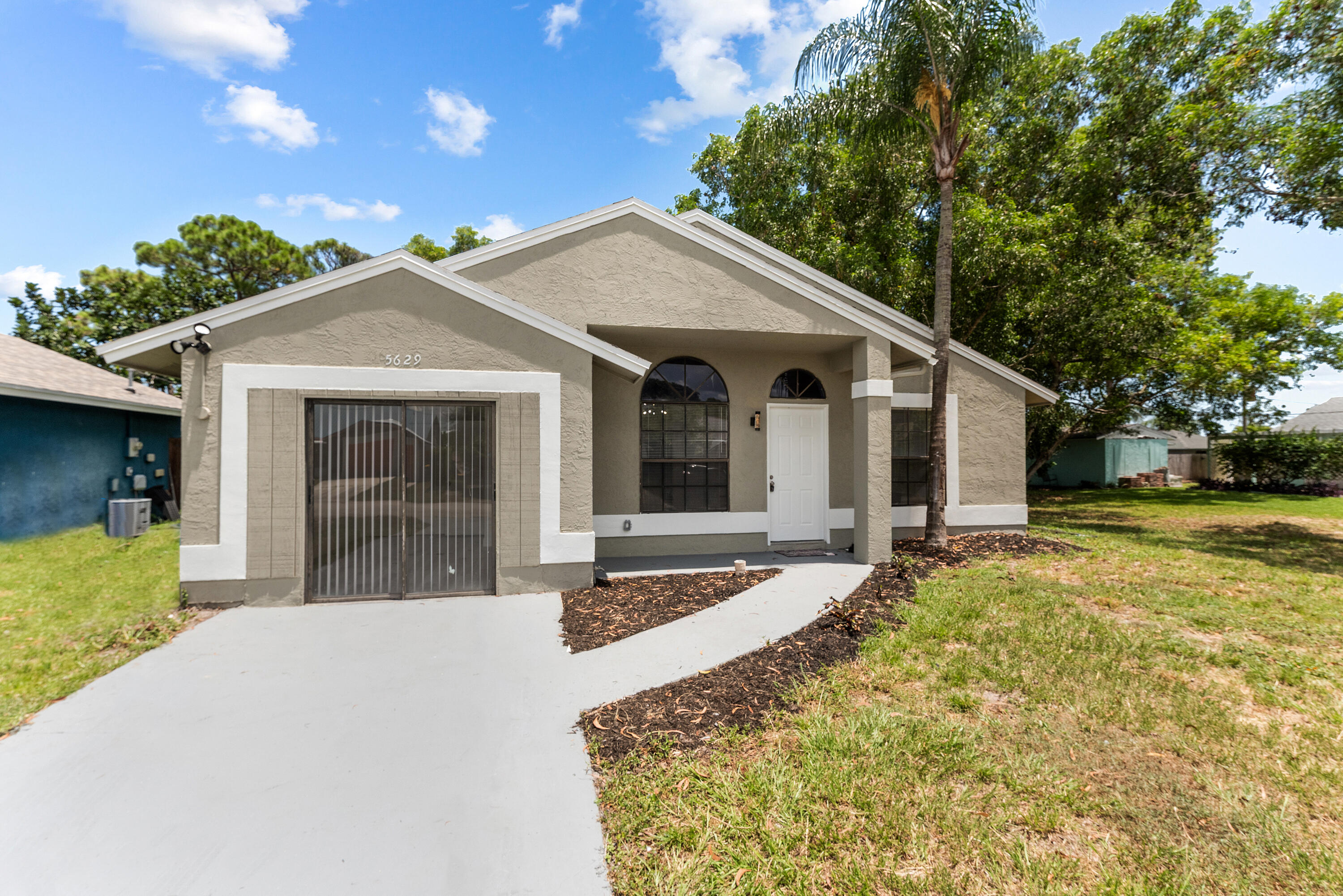 5629 Southeast Collins Avenue Stuart, FL 34997 - Photo 38 of 39 a front view of a house with a yard outdoor seating and garage