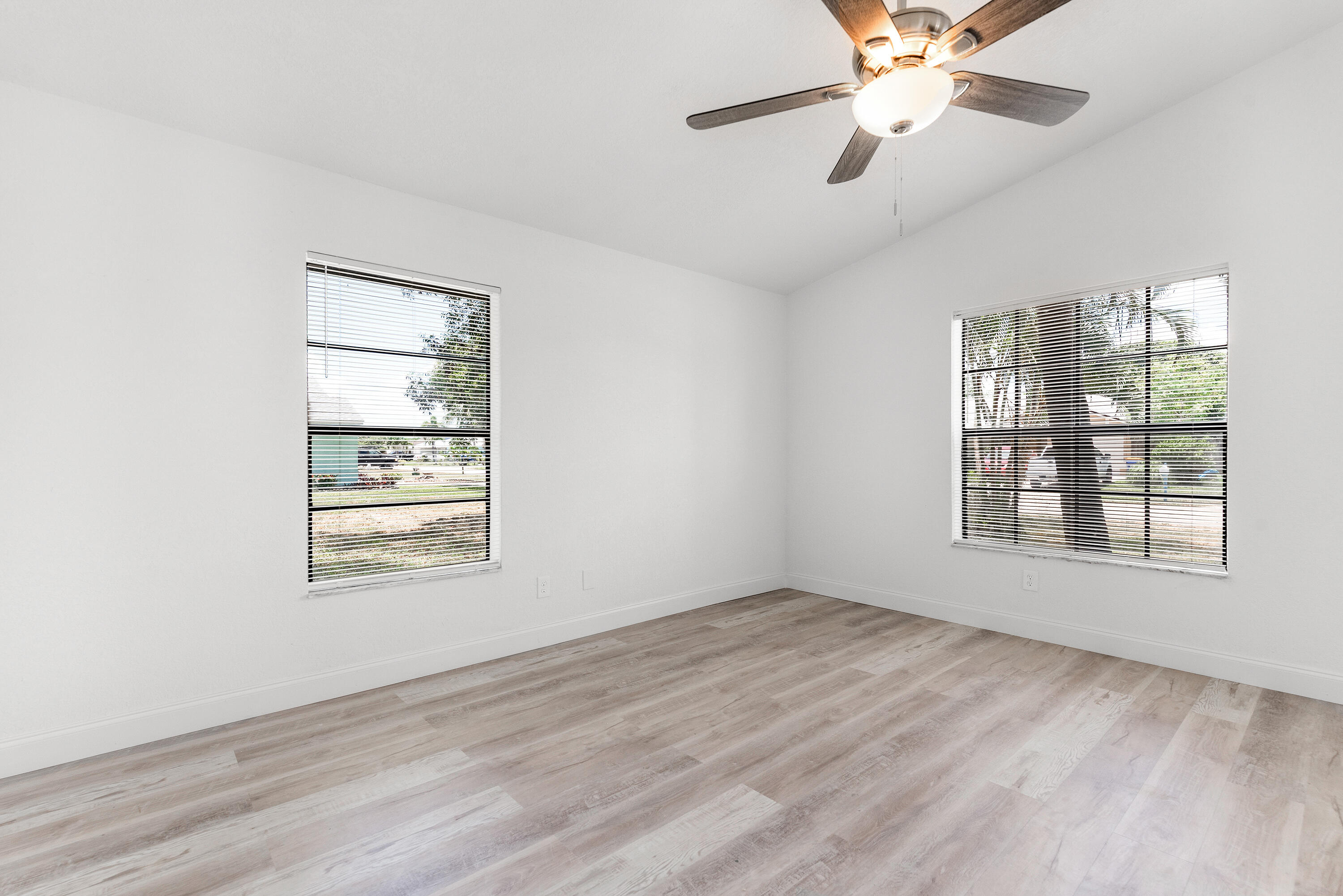 5629 Southeast Collins Avenue Stuart, FL 34997 - Photo 6 of 39 a view of an empty room with a window and wooden floor