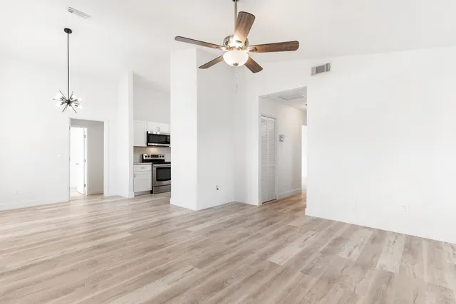 a view of an empty room with a kitchen