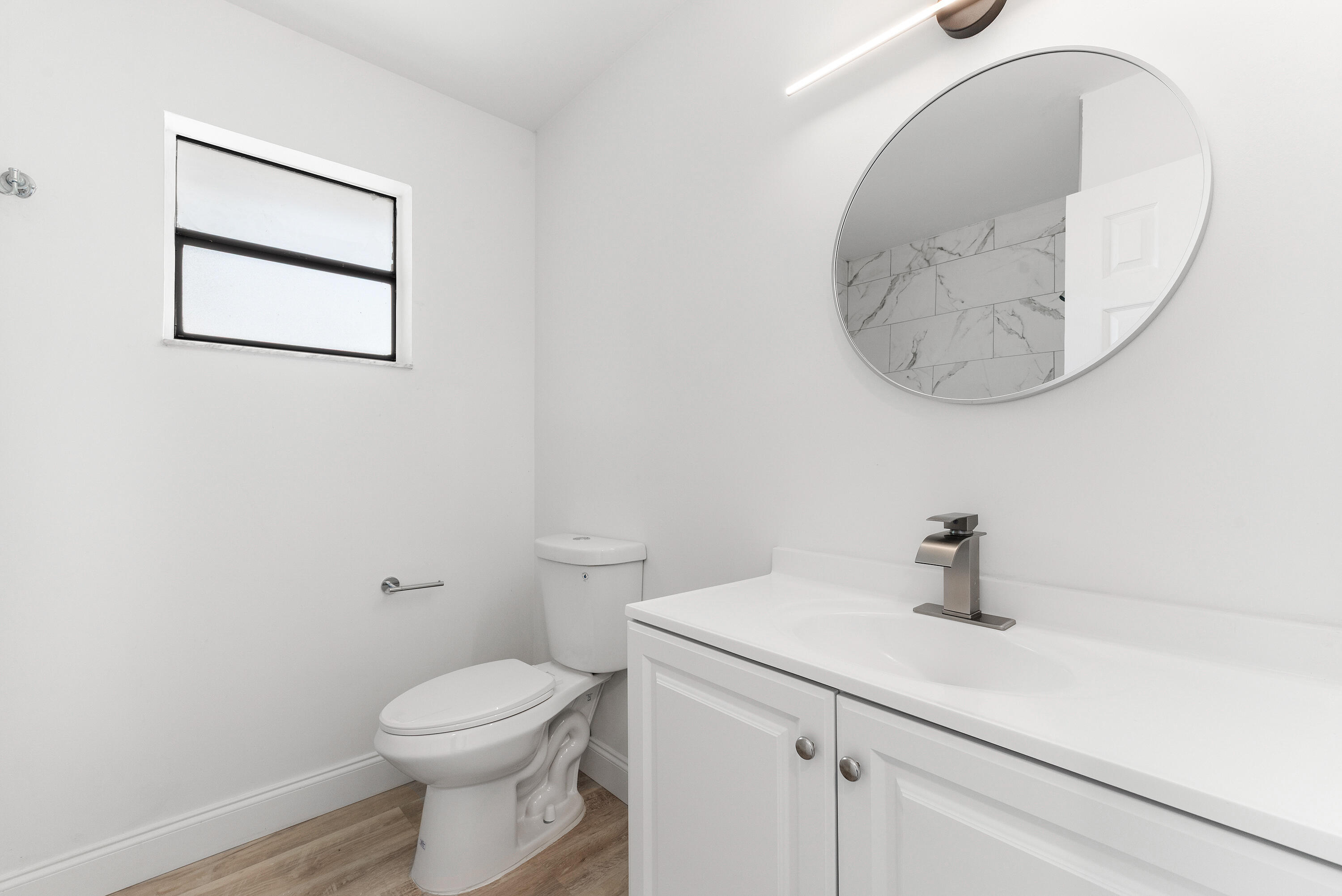 5629 Southeast Collins Avenue Stuart, FL 34997 - Photo 9 of 39 a bathroom with a sink a mirror and toilet