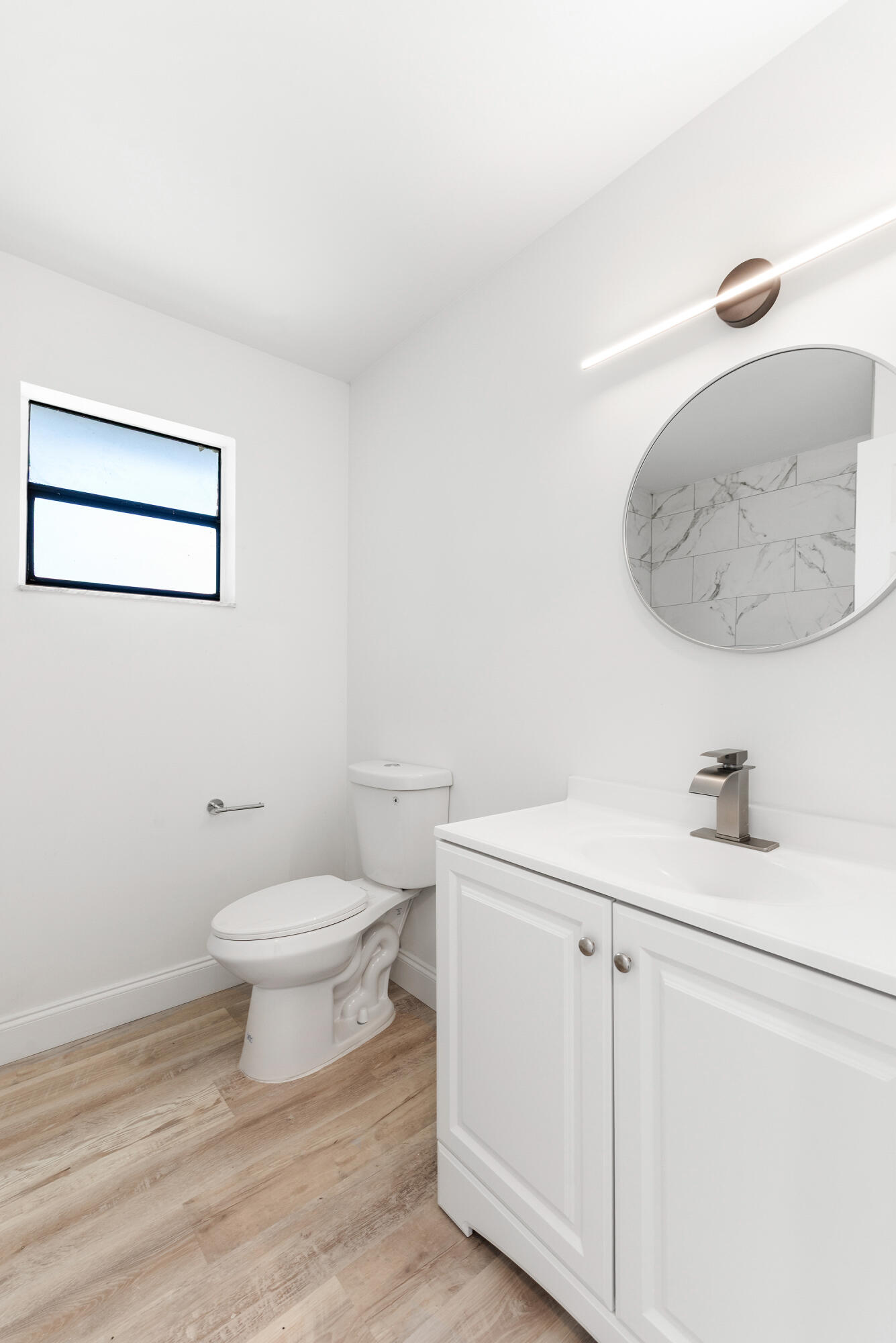 5629 Southeast Collins Avenue Stuart, FL 34997 - Photo 10 of 39 a bathroom with a toilet a sink a vanity and mirror