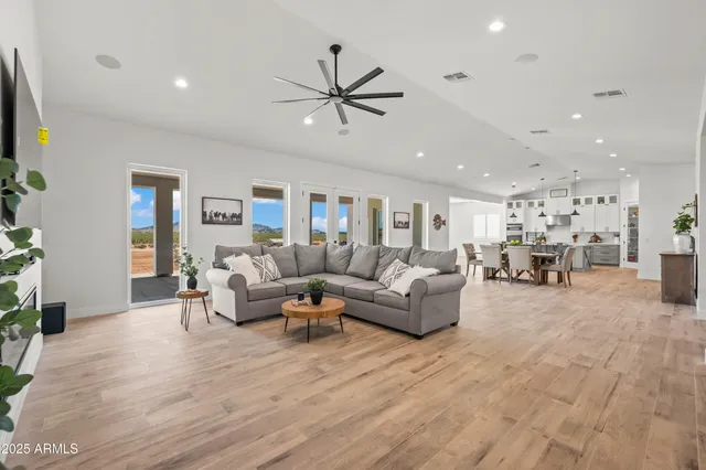 a living room with furniture and a large window with wooden floor