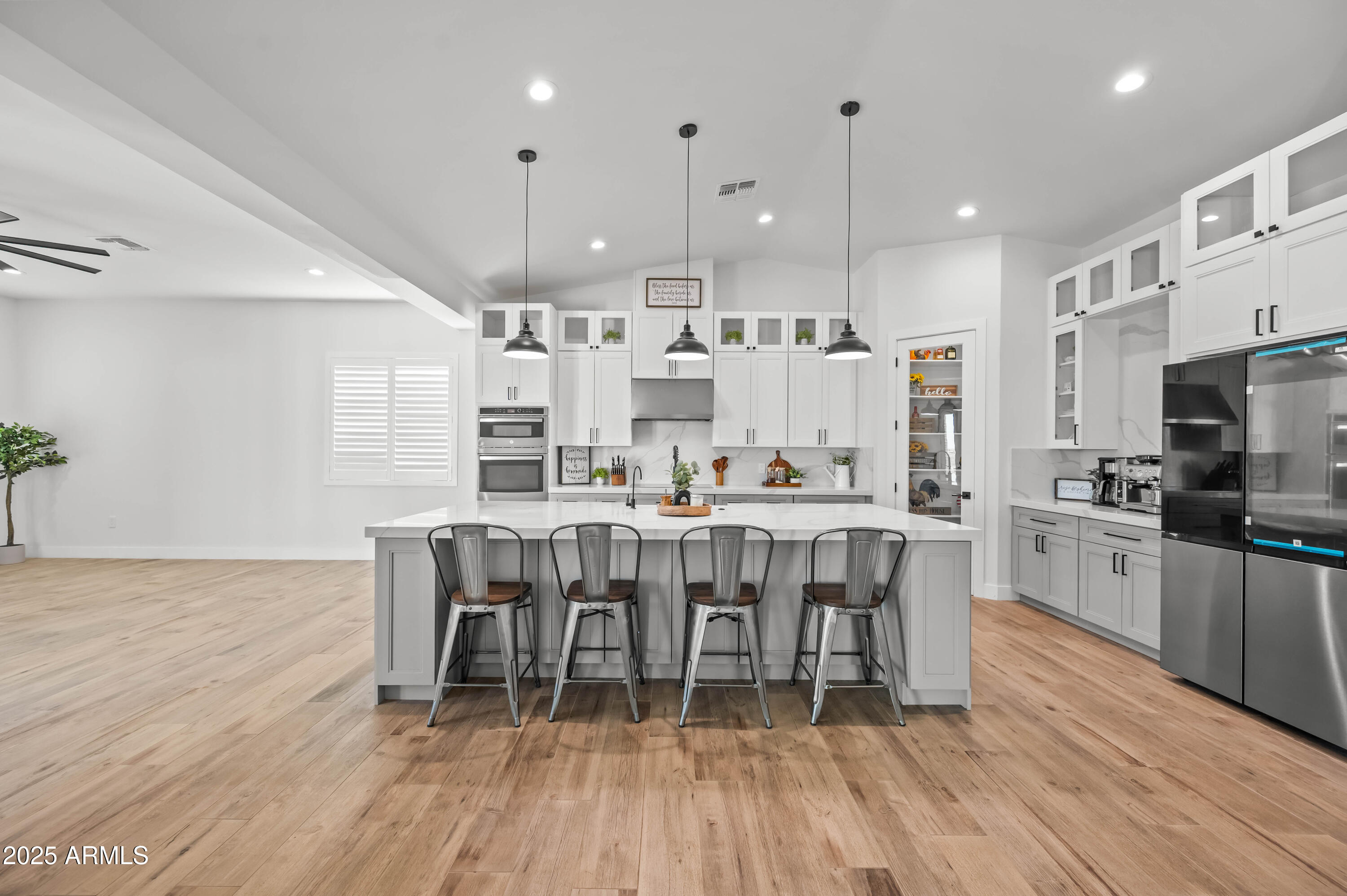 22145 West Harwell Road Buckeye, AZ 85326 - Photo 29 of 86 a large dining hall with stainless steel appliances granite countertop a stove a refrigerator a kitchen island a dining table and chairs with wooden floor