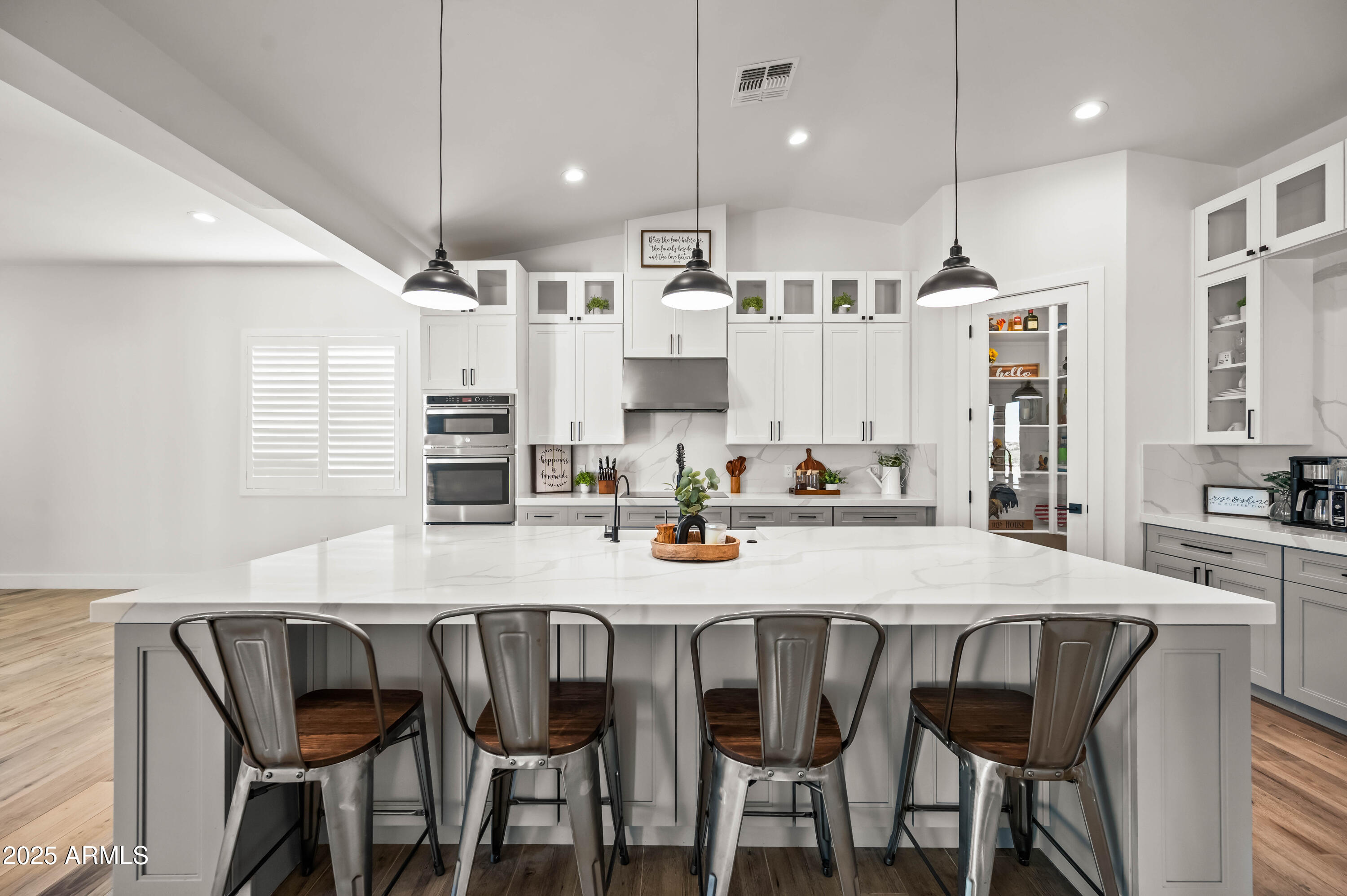 22145 West Harwell Road Buckeye, AZ 85326 - Photo 34 of 86 a kitchen with stainless steel appliances kitchen island granite countertop a dining table chairs and white cabinets