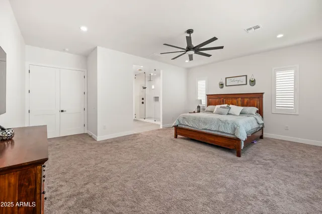 a bedroom with a bed a dresser and a potted plant