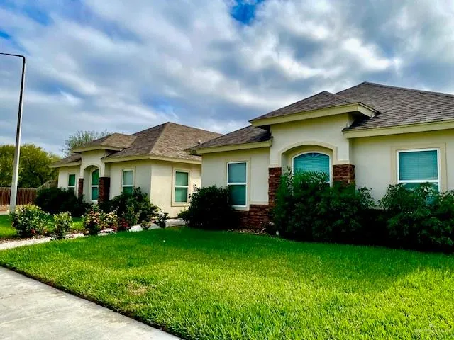 a front view of a house with a garden and plants