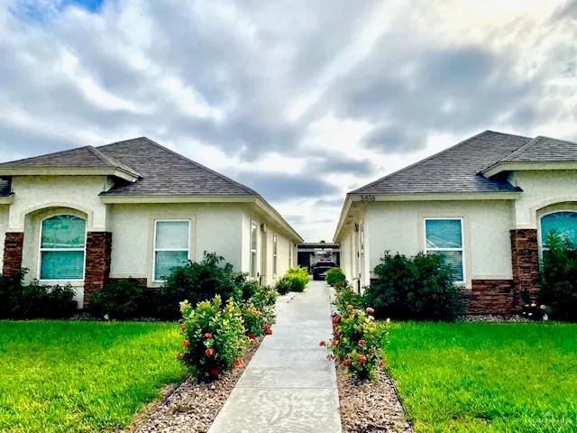 a front view of a house with a garden and plants