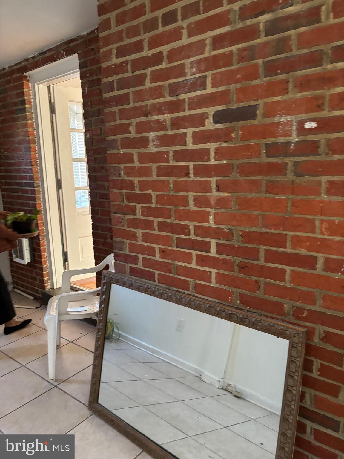 8028 Eastern Avenue Northwest Washington, DC 20012 - Photo 27 of 54 a view of a brick wall with chair and a potted plant on a bench