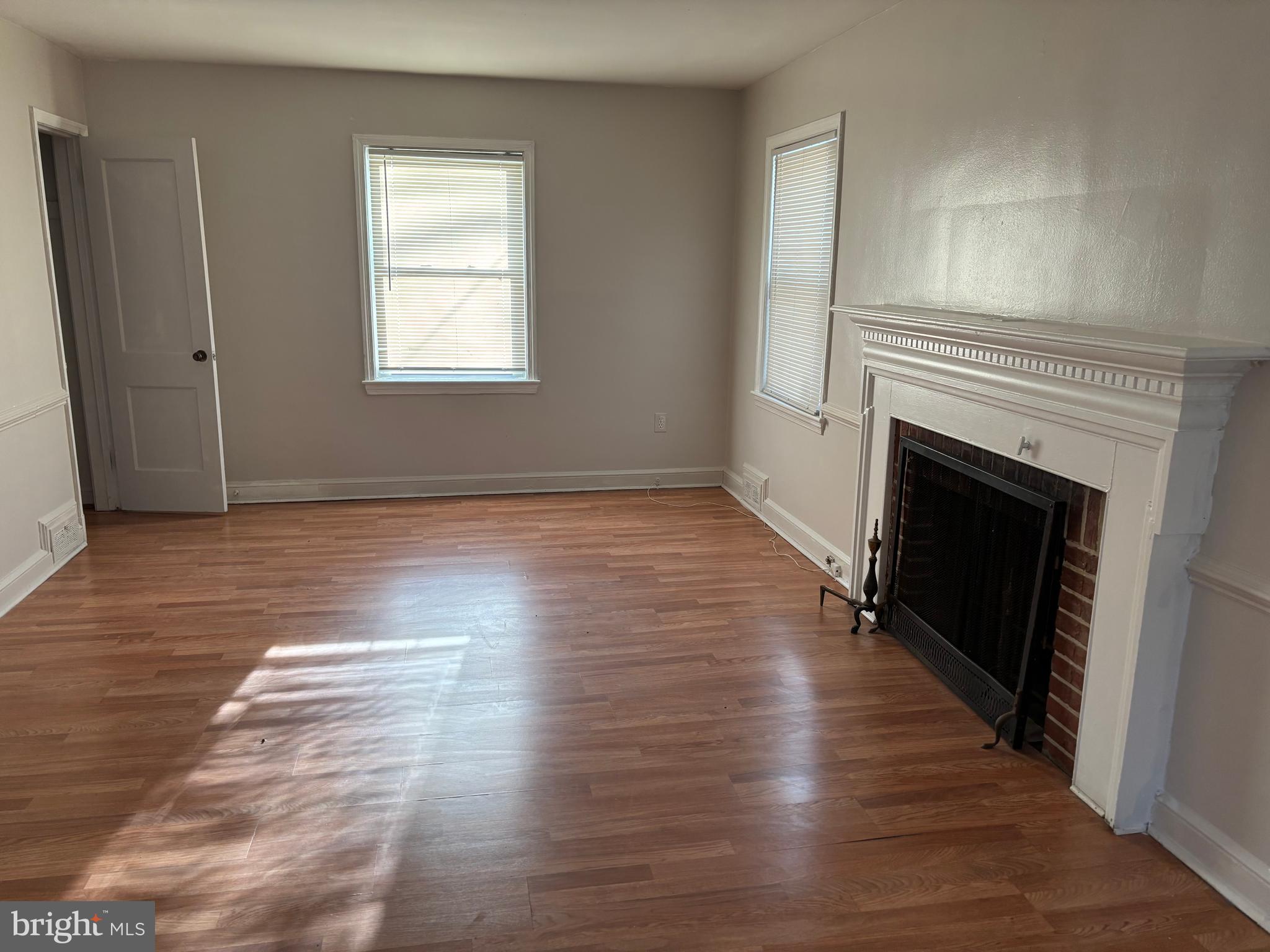 8028 Eastern Avenue Northwest Washington, DC 20012 - Photo 53 of 54 an empty room with wooden floor fireplace and windows