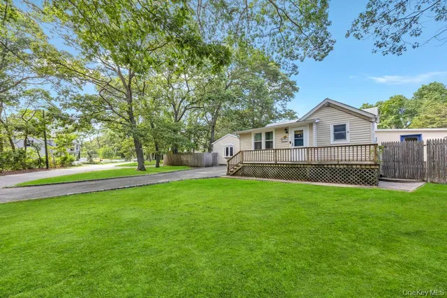 a view of a house with a backyard and a tree