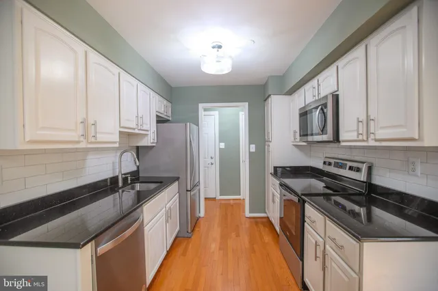 a kitchen with stainless steel appliances a sink stove and cabinets
