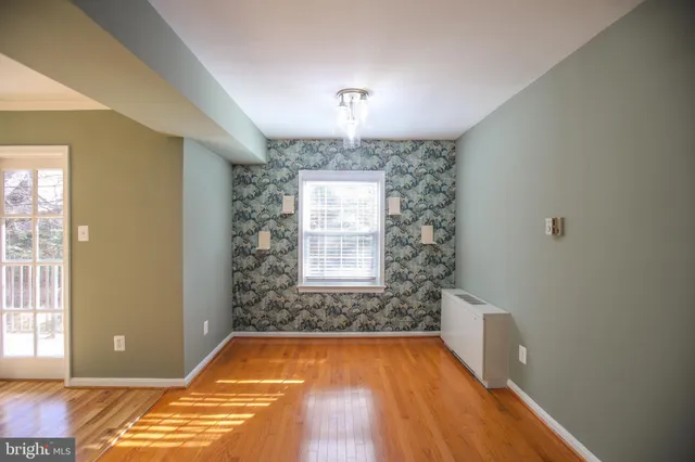 a view of a livingroom with wooden floor and a ceiling fan