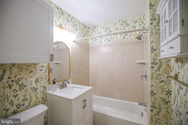 a bathroom with a sink mirror toilet and bathtub