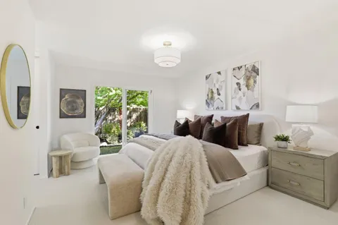 a spacious bedroom with a bed a couch and dresser