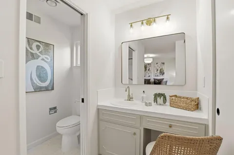 a bathroom with a toilet a sink and a mirror