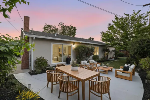 a view of a patio with a table and chairs under an umbrella