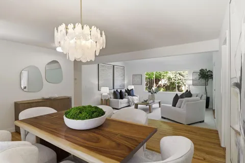 a living room with furniture a chandelier and a table