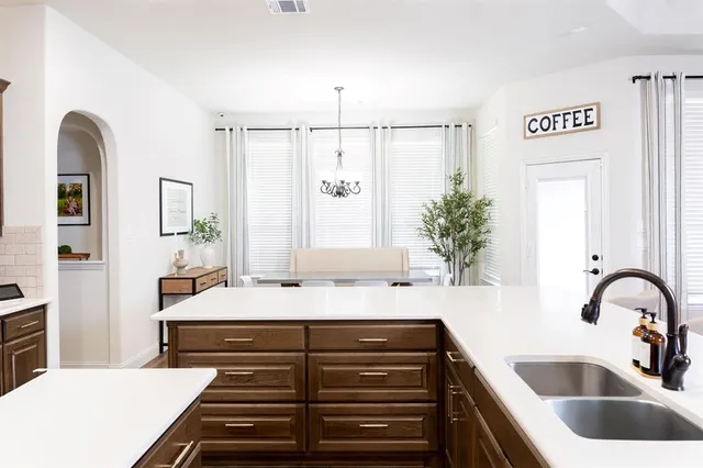 a kitchen with stainless steel appliances granite countertop a sink stove microwave and refrigerator