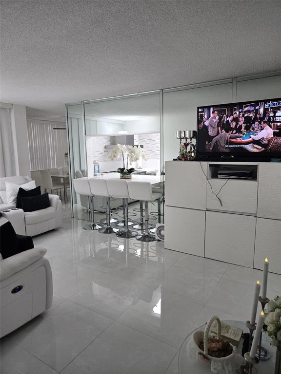 a living room with furniture and a kitchen area