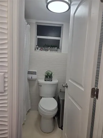 a white toilet sitting next to a bathroom sink