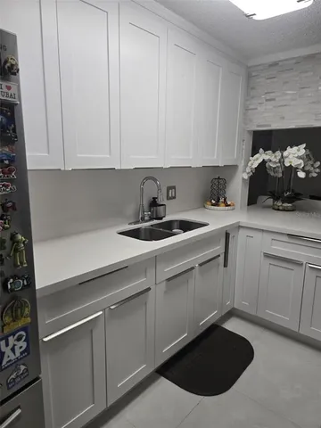 a kitchen with stainless steel appliances granite countertop a sink dishwasher a stove and white cabinets