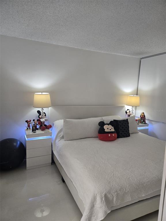 9410 Live Oak Place, Unit 103 Davie, FL 33324 - Photo 17 of 49 a bed room with a bed and a lamp