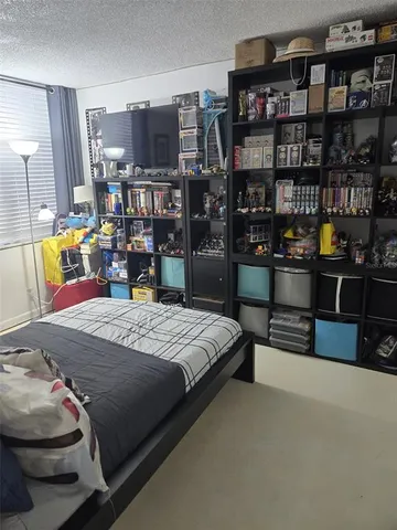 a bedroom with a bed a table and a book shelf