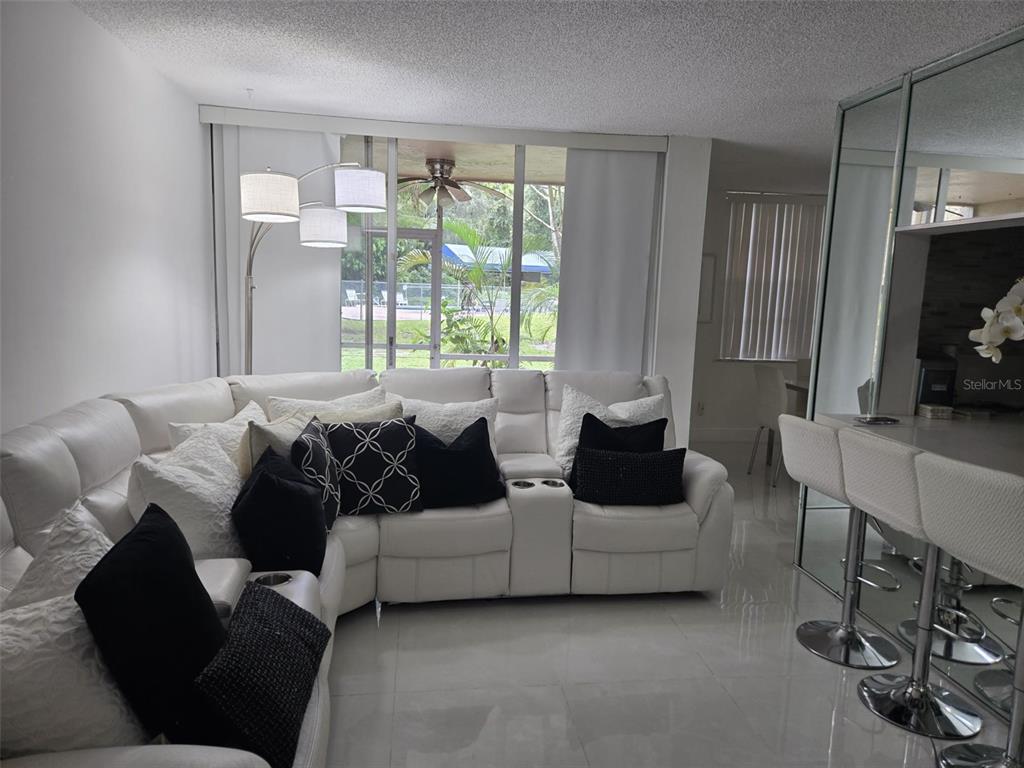 9410 Live Oak Place, Unit 103 Davie, FL 33324 - Photo 3 of 49 a living room with furniture and a flat screen tv