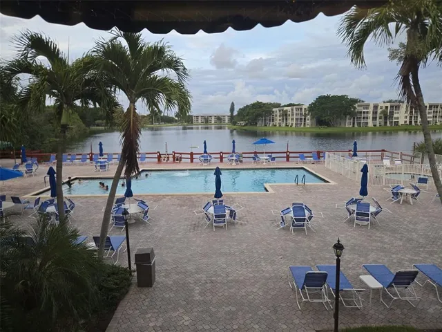 a swimming pool with outdoor seating and a kitchen