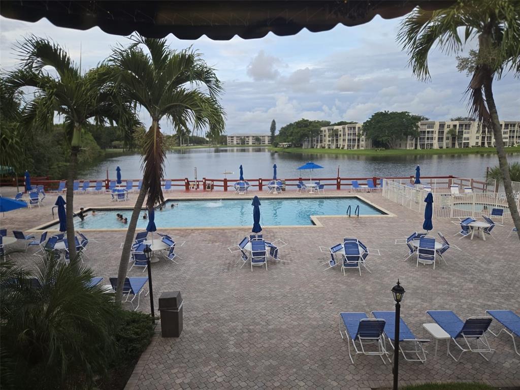 9410 Live Oak Place, Unit 103 Davie, FL 33324 - Photo 47 of 49 a swimming pool with outdoor seating and a kitchen