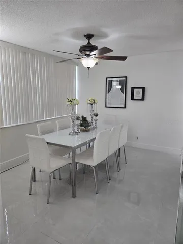 a view of a dining room with furniture and a chandelier fan