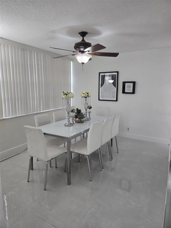 9410 Live Oak Place, Unit 103 Davie, FL 33324 - Photo 6 of 49 a view of a dining room with furniture and a chandelier fan