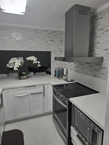 a kitchen with stainless steel appliances a sink stove and cabinets