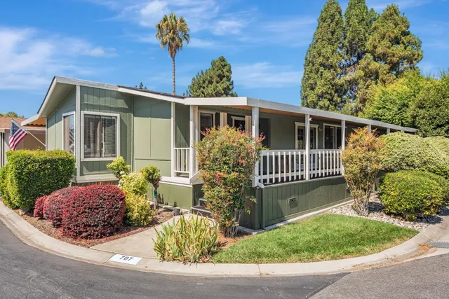 a living room with furniture a flat screen tv and wooden floor