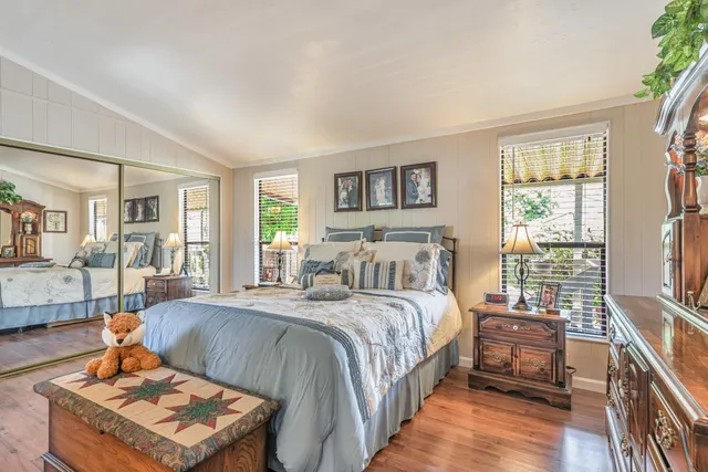 a bedroom with a bed a bookshelf and a window