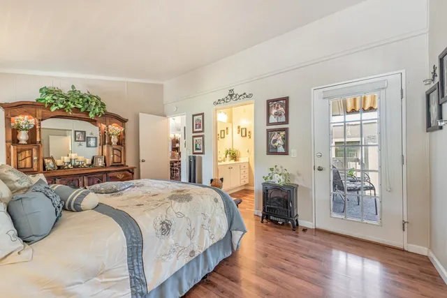 a spacious bedroom with a bed and wooden floor
