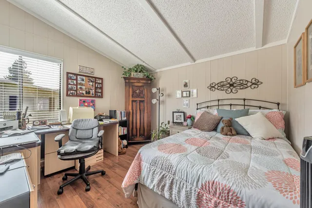 a bedroom with a large bed and windows