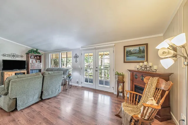 a living room with furniture a flat screen tv and wooden floor