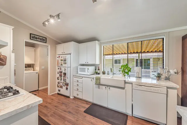 a kitchen with appliances cabinets and a large window