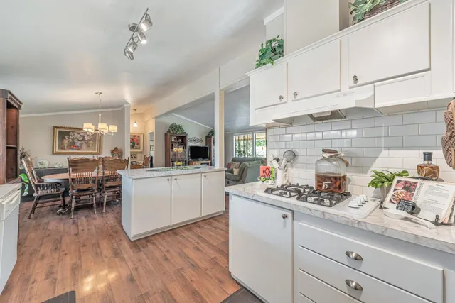 a open kitchen with white cabinets a dining table and chairs