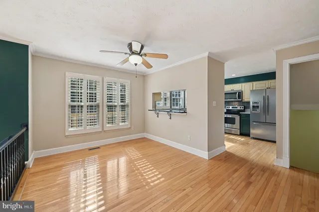 a view of empty room with wooden floor and windows